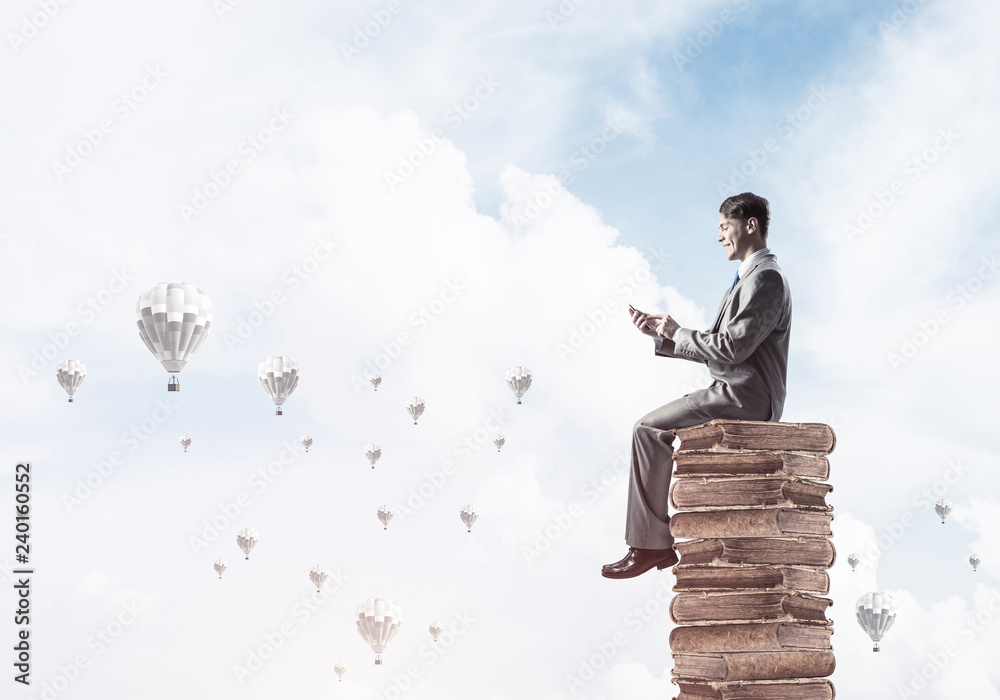 Man businessman on stack reading book and aerostats flying aroun