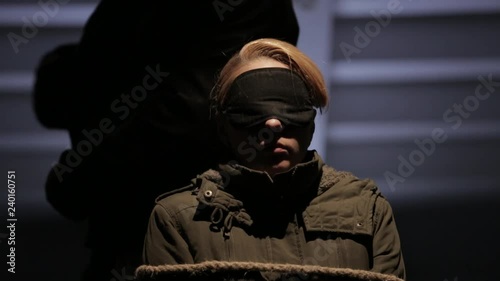 Kidnapped tied woman on the chair. The criminal makes an injection into the neck