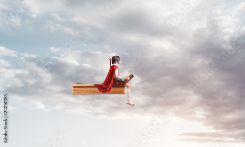 Girl power concept with cute kid guardian against cloudscape bac