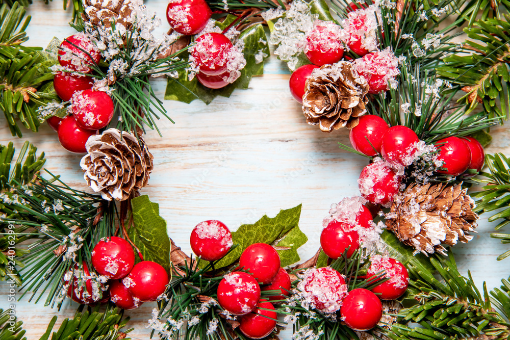 Beautiful frame from green branches of a Christmas tree with traditional Christmas wreath on a blue board with a place for the inscription Beautiful frame from green branches of a Christmas tree with traditional Christmas wreath on a blue board with a place for the inscription