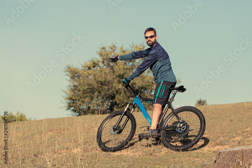 Cyclist in shorts and jersey on a modern carbon hardtail bike with an air suspension fork 