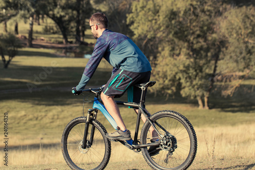 Cyclist in shorts and jersey on a modern carbon hardtail bike with an air suspension fork  © Mountains Hunter