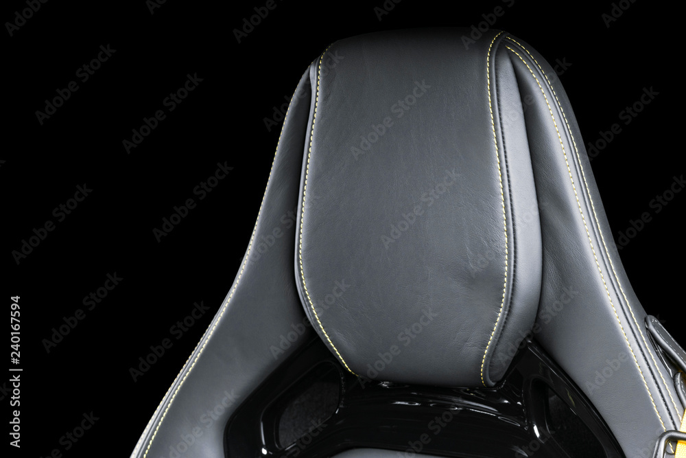 Black leather interior of the luxury modern car. Perforated Leather comfortable seats with yellow stitching isolated on black background. Modern car interior details. Car detailing. Car inside