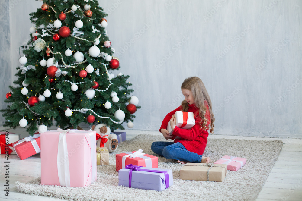 little girl opens Christmas presents new year tree little girl opens Christmas presents new year tree