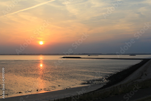 beautiful sunset at sea with low tide and a pier in the water