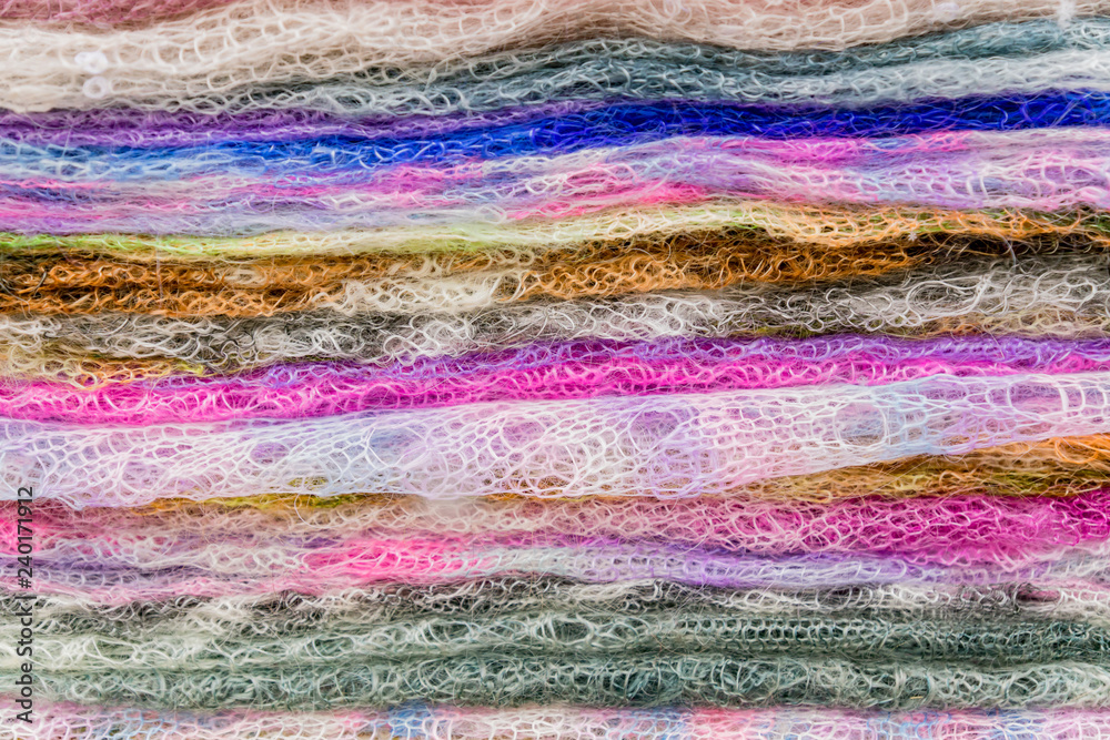 Obraz premium Stack of knitted downy scarfs for background. Russian famous Orenburg shawls. Crochet, pattern.