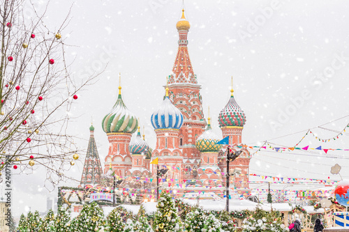 Christmas decorations on Red Square in Moscow on background of St. Basil's Cathedral. Winter holiday postcard from Red Square under snowfall.