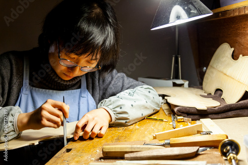 Fotografie female artisan violinmaker while viewing a new violin