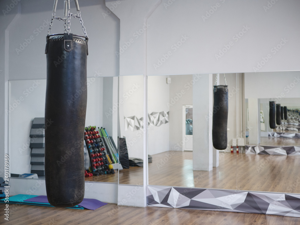 punching bag hanging in fight club fitness gym with mirror in mirror  infinity effect Stock Photo