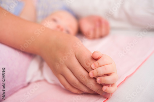 Hand The Sleeping Caucasian Baby In The Hand Of Mother Close Up. New Family And Baby Protection From Mom Concept.