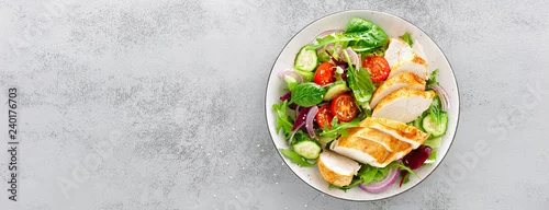 Obraz Grillowana pierś z kurczaka, filet i sałata ze świeżych warzyw, sałata, rukola, szpinak, ogórek i pomidor. Zdrowe menu na lunch. Dietetyczne jedzenie. Widok z góry. Transparent