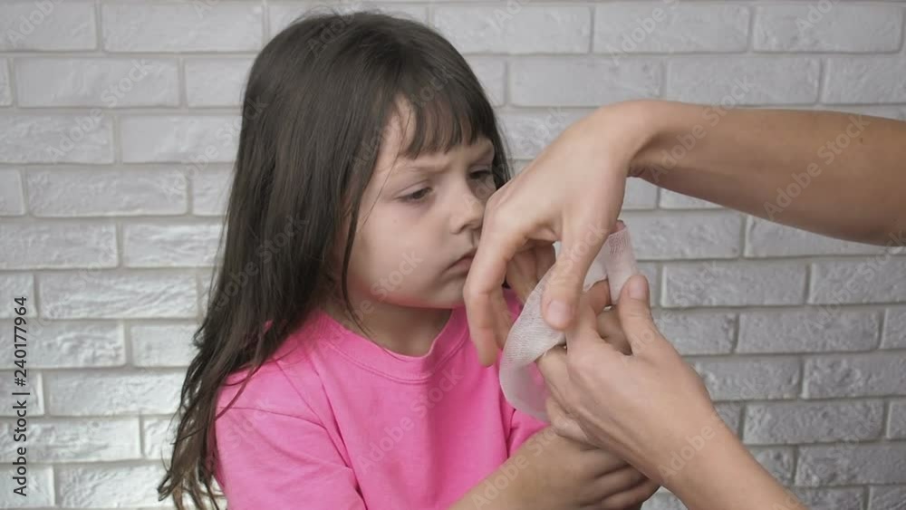 Kids finger ligation. A little girl is bandaging her finger on her hand. Kids finger ligation. A little girl is bandaging her finger on her hand.