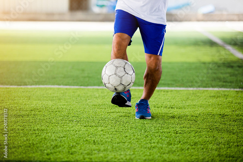Soccer player speed run to shoot ball to goal on artificial turf
