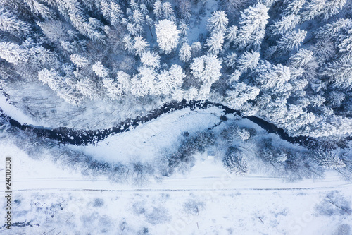 Aerial view on the river and forest at the winter time. Natural winter landscape from air. Forest under snow a the winter time. Landscape from drone