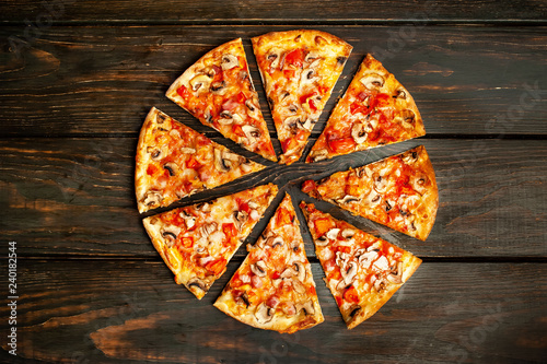 delicious fresh italian pizza on a wooden background straight from the oven.
