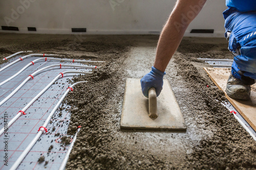 Screed flooring. Worker at a construction site screed floor. photo