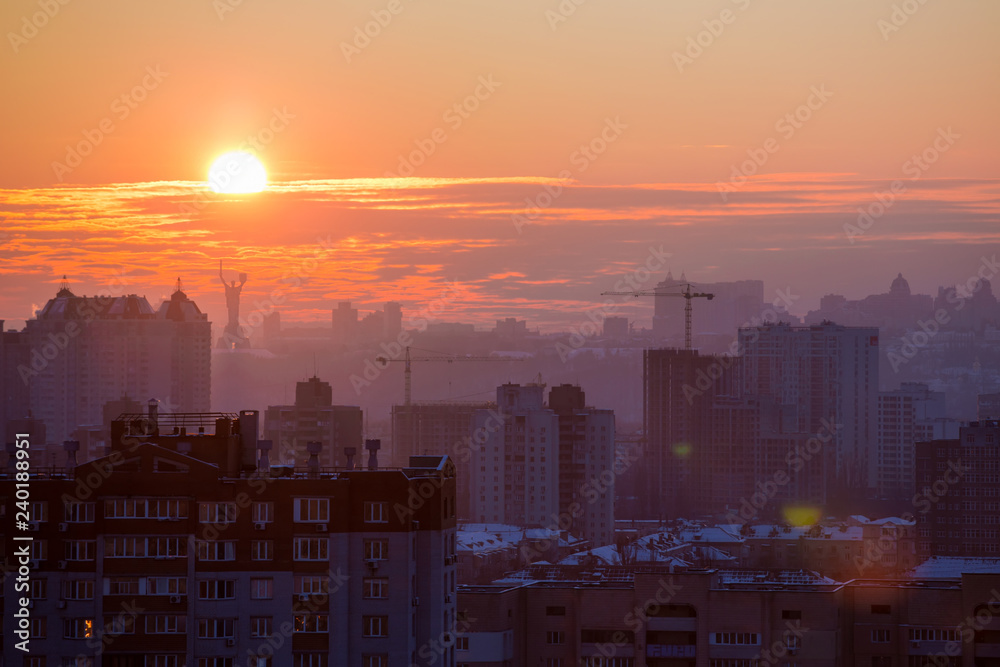 Fototapeta premium Sunset in Kiev, evening view of the panorama of the city, the church and the statue of the Motherland. Evening color urban landscape
