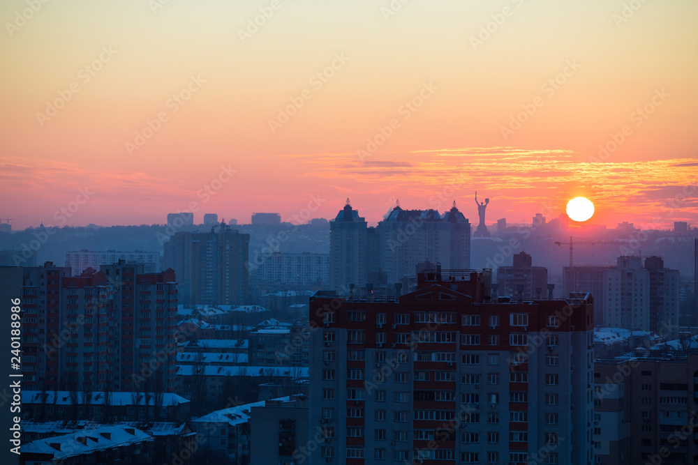 Fototapeta premium Sunset in Kiev, evening view of the panorama of the city, the church and the statue of the Motherland. Evening color urban landscape