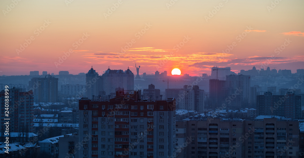 Sunset in Kiev, evening view of the panorama Kiev city. Red sun, fog and smog in the capital of Ukraine