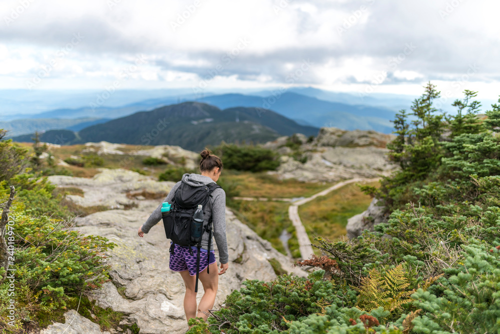 female hiker finds her footing hiking along Mount Mansfield in Vermont
