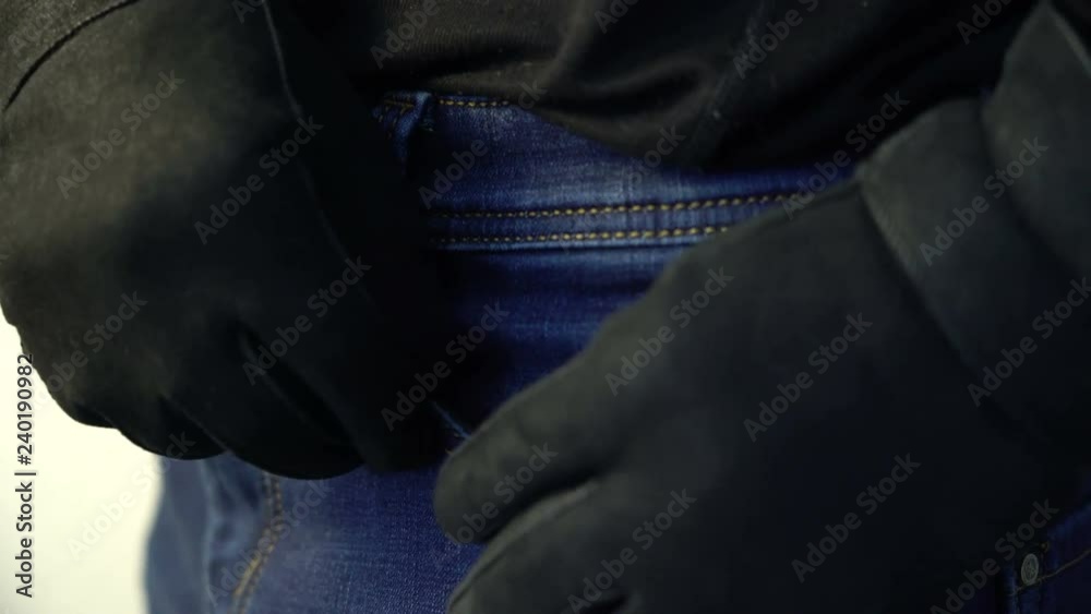 man in black gloves hiding money in his pocket crime fraud concept man in black gloves hiding money in his pocket crime fraud concept