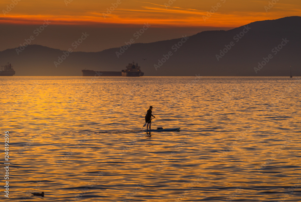 woman on paddlebard at sunset woman on paddlebard at sunset
