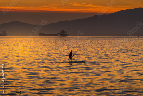 woman on paddlebard at sunset © eileen10