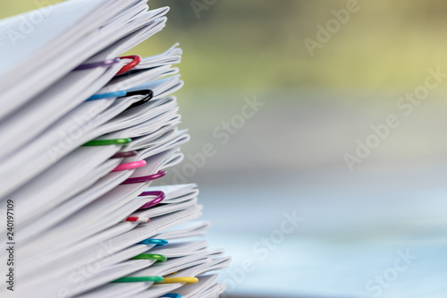 Billede på lærred Close up pile of unfinished homework assignment stacked in archive with colorful paper clips on table in school waiting to be managed and inspected