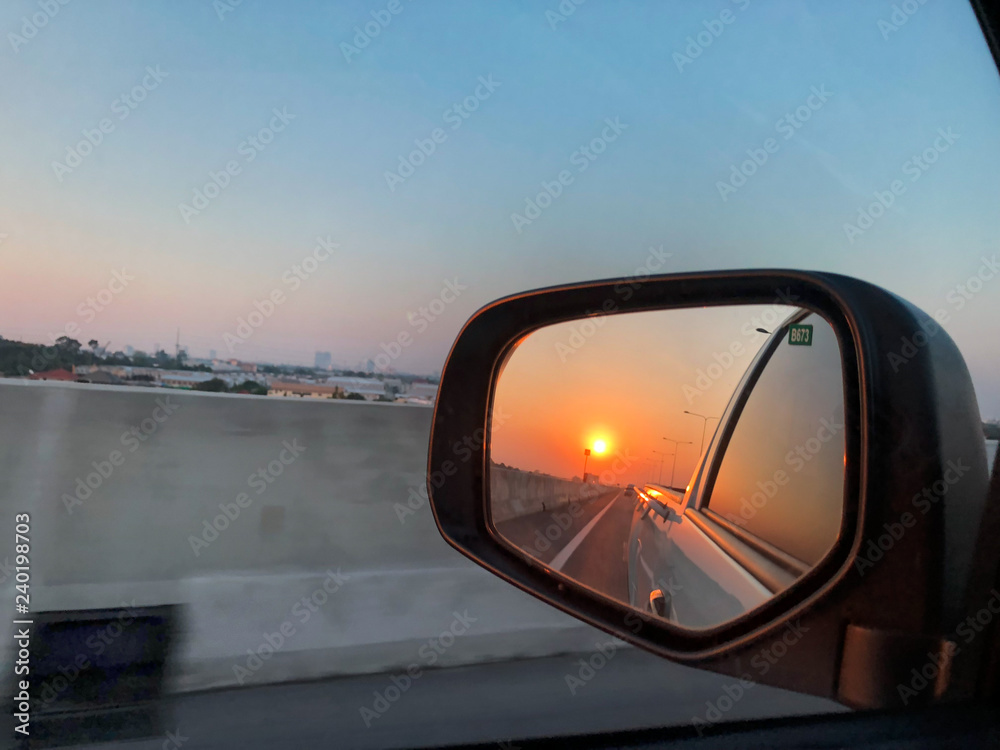 Beautiful sunset reflect in mirror of car.