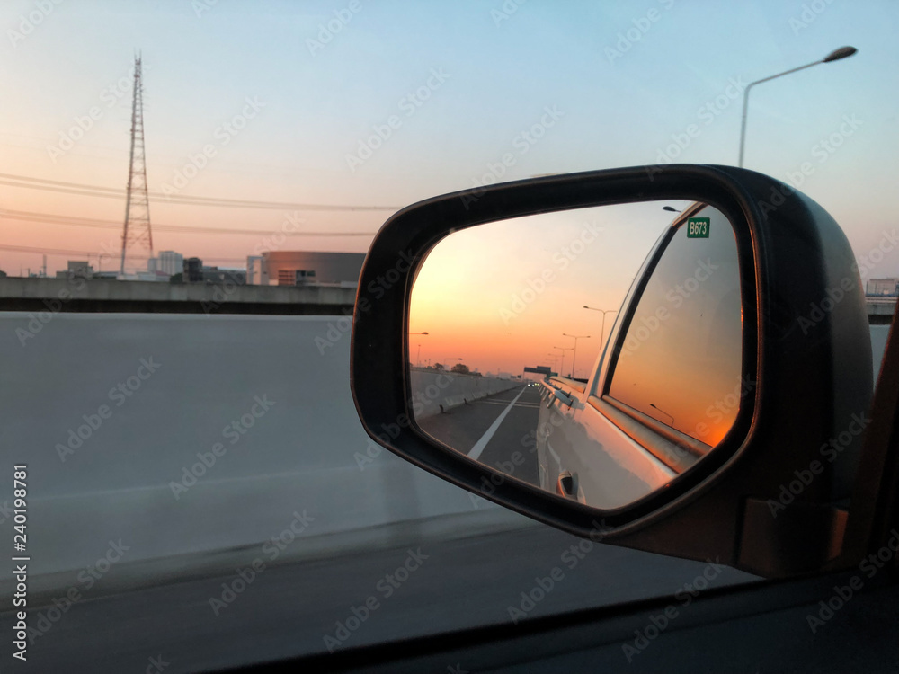 Beautiful sunset reflect in mirror of car.