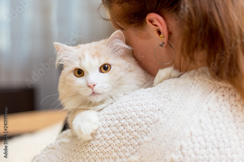 Young woman is playing with her cat