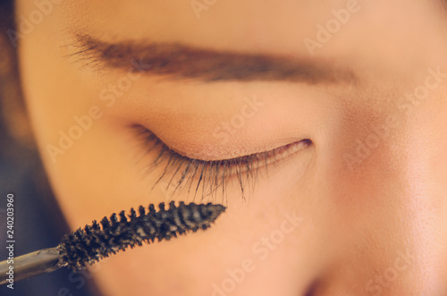 Beauty face of woman by applying mascara on face and smooth skin by cosmetics.