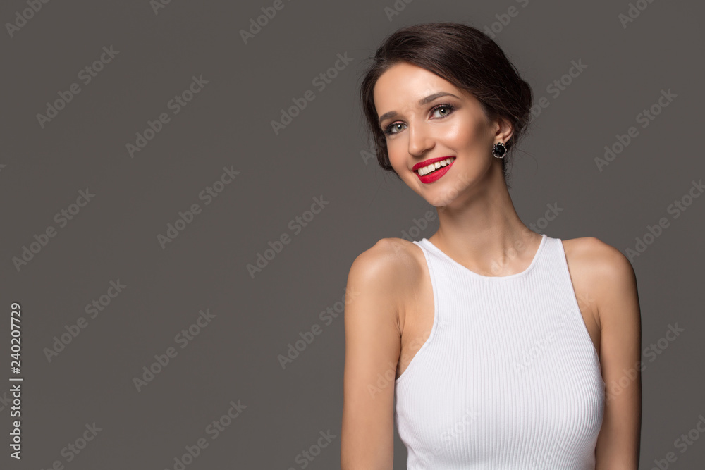 Fashion woman in white dress and beautiful smile, bright make-up. Gray background Fashion woman in white dress and beautiful smile, bright make-up. Gray background