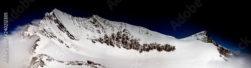 panorama view of the view of the Lenzspitze peak and the Nadelhorn peak under a blue sky in the Alps of Switzerland