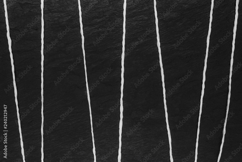 Abstract composition of white thread on black stone background surface Abstract composition of white thread on black stone background surface