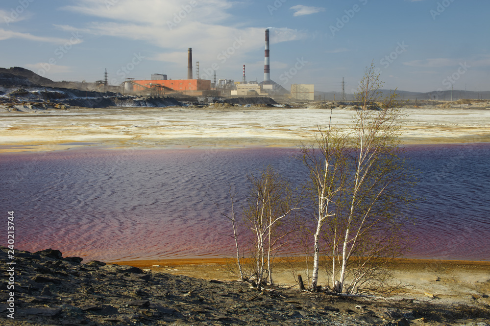 Lake with toxic waste on a background of chimneys copper smelting plant.