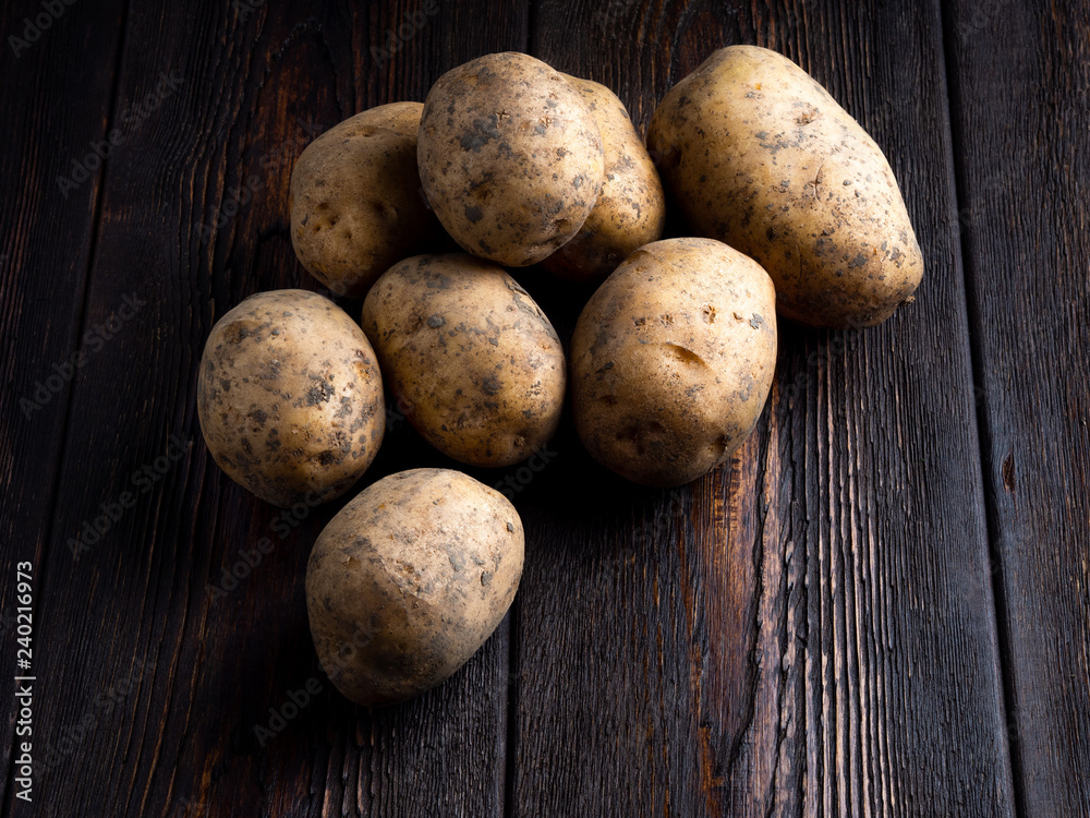 Potatoes on a dark brown wooden background Potatoes on a dark brown wooden background