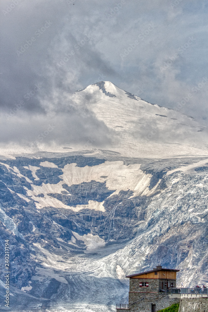 Bergspitze im Nebel mit Gletscher und Berghütte