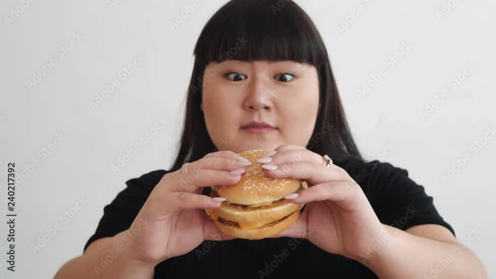 fat girl holding a bad hamburger and happy. fast food unhealthy food fat girl holding a bad hamburger and happy. fast food unhealthy food