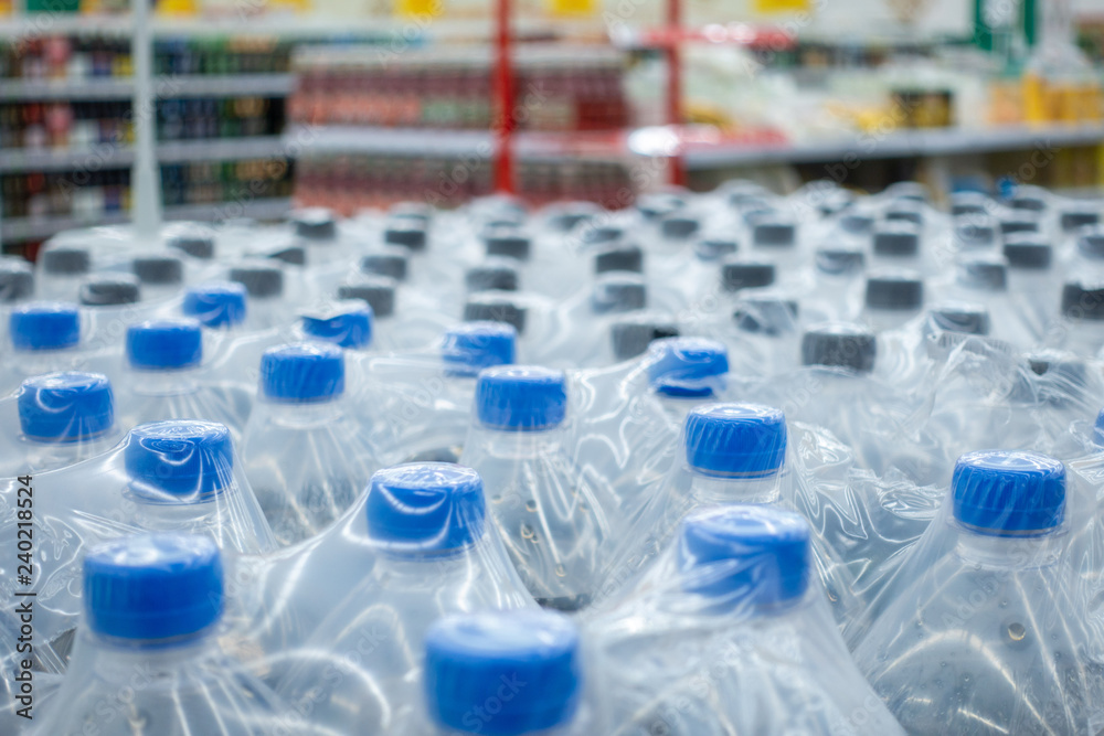 Plastic bottles in packs. Water bottles - plastic bottles factory warehouse store food background. Plastic bottles in packs. Water bottles - plastic bottles factory warehouse store food background.
