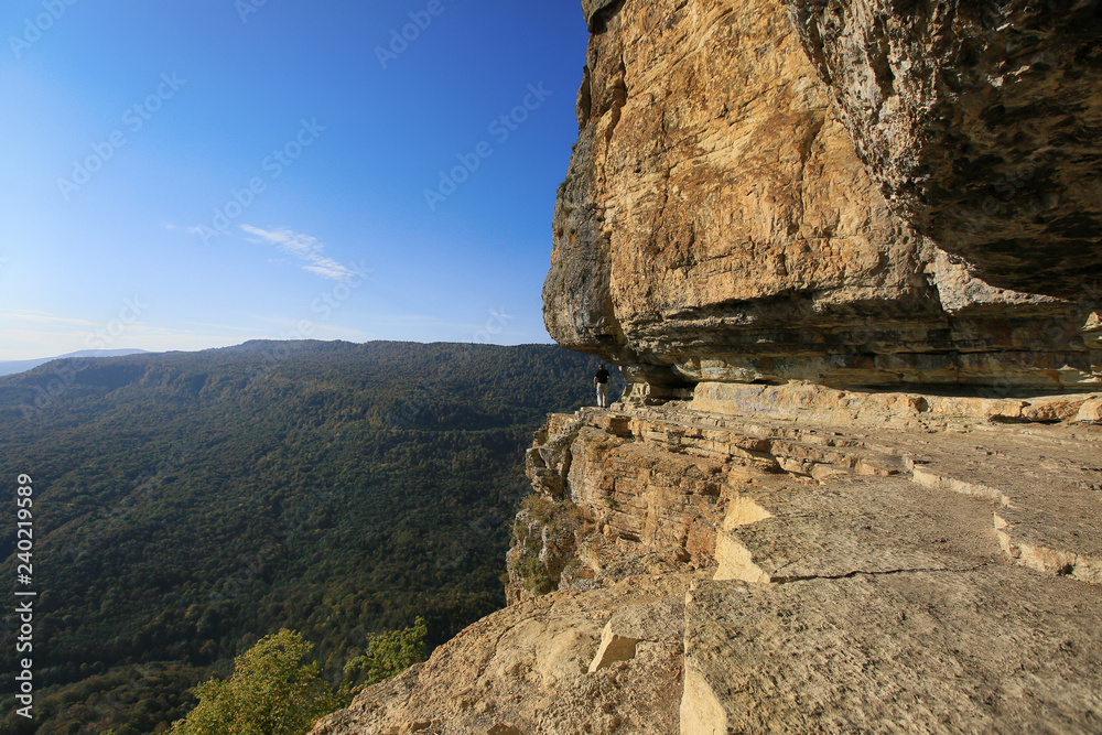 Mountain village Mezmay in Absheron district of Krasnodar region in Russia. Man at the mountain cliff on the Eagle shelf