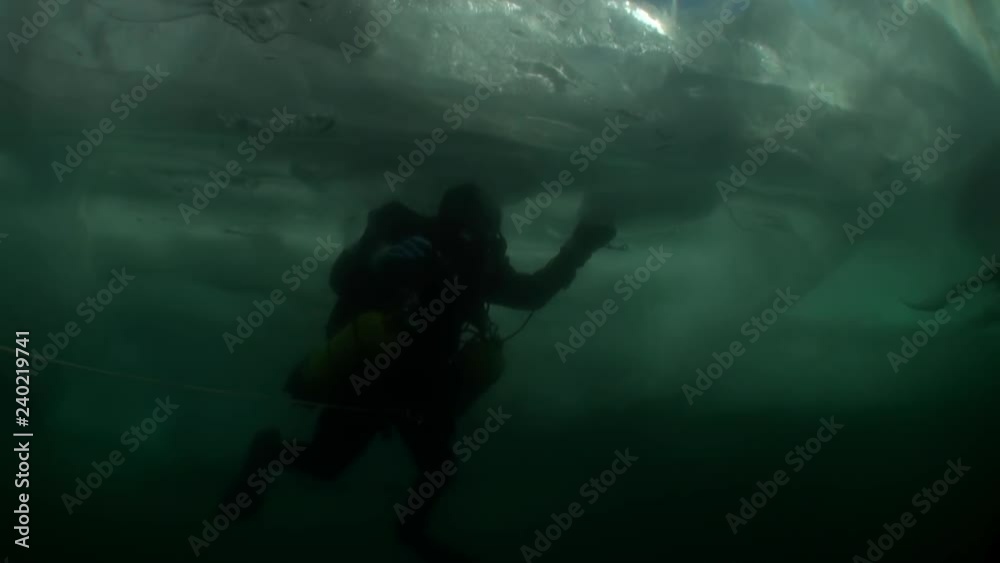 Diver under ice underwater in cold water of lake Baikal. Diver under ice underwater in cold water of lake Baikal.