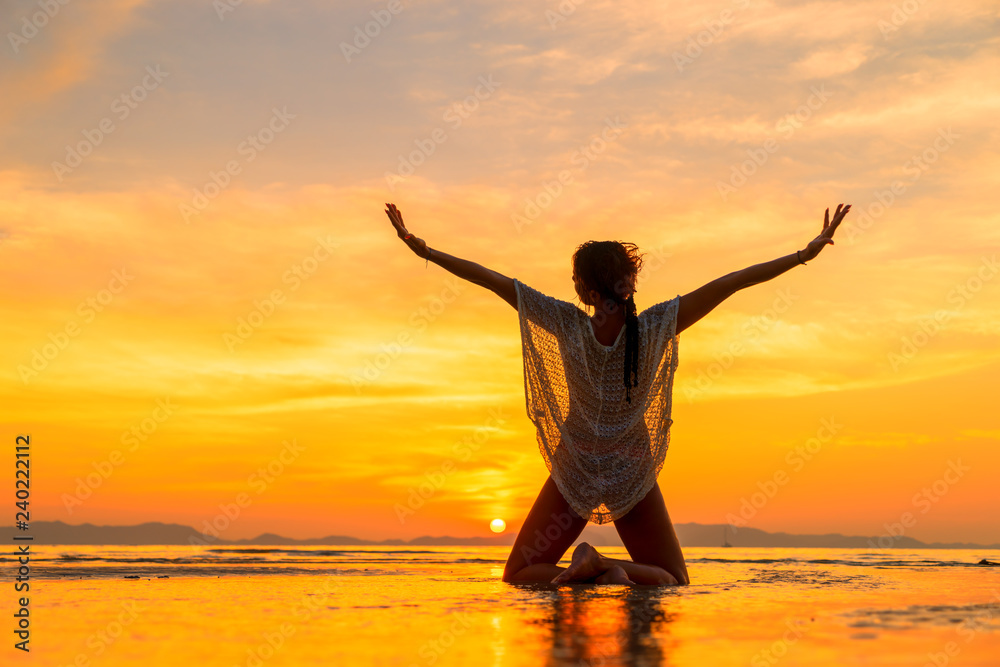 Beautiful Woman at the beach in Thailand at sunset