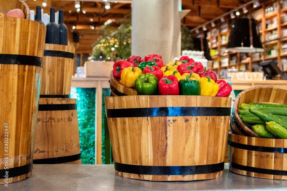 colorful sweet peppers in a wooden barrel at the market