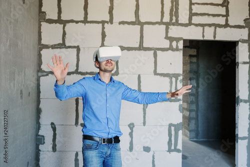 Builder projecting with VR glasses future interior standing at the construction site