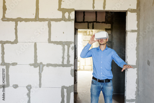 Builder projecting with VR glasses future interior standing at the construction site © oes