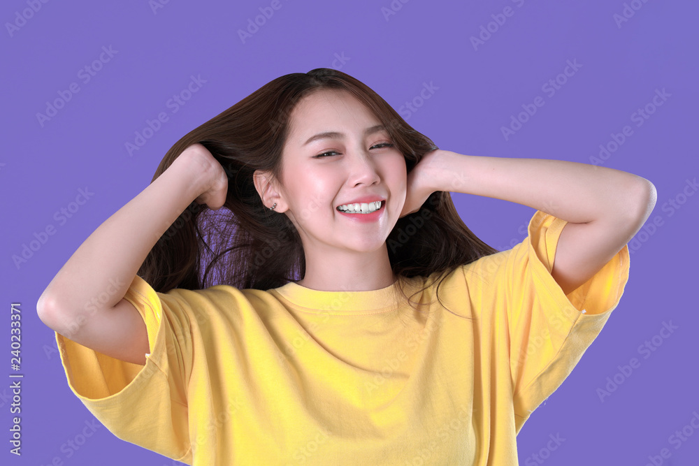 Asian woman spread hair, yellow t-shirt clothing, purple background Asian woman spread hair, yellow t-shirt clothing, purple background