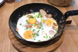 Three fried eggs with sausage