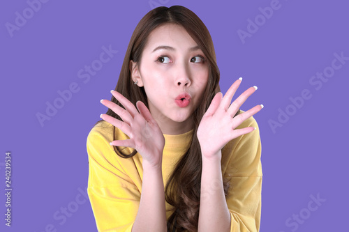 Asian woman shouting for special promotion, yellow t-shirt clothing, purple background