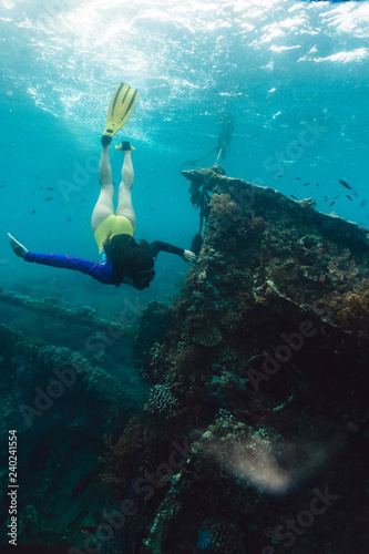 Girl freediver explores the old sunken ship in the Caribbean